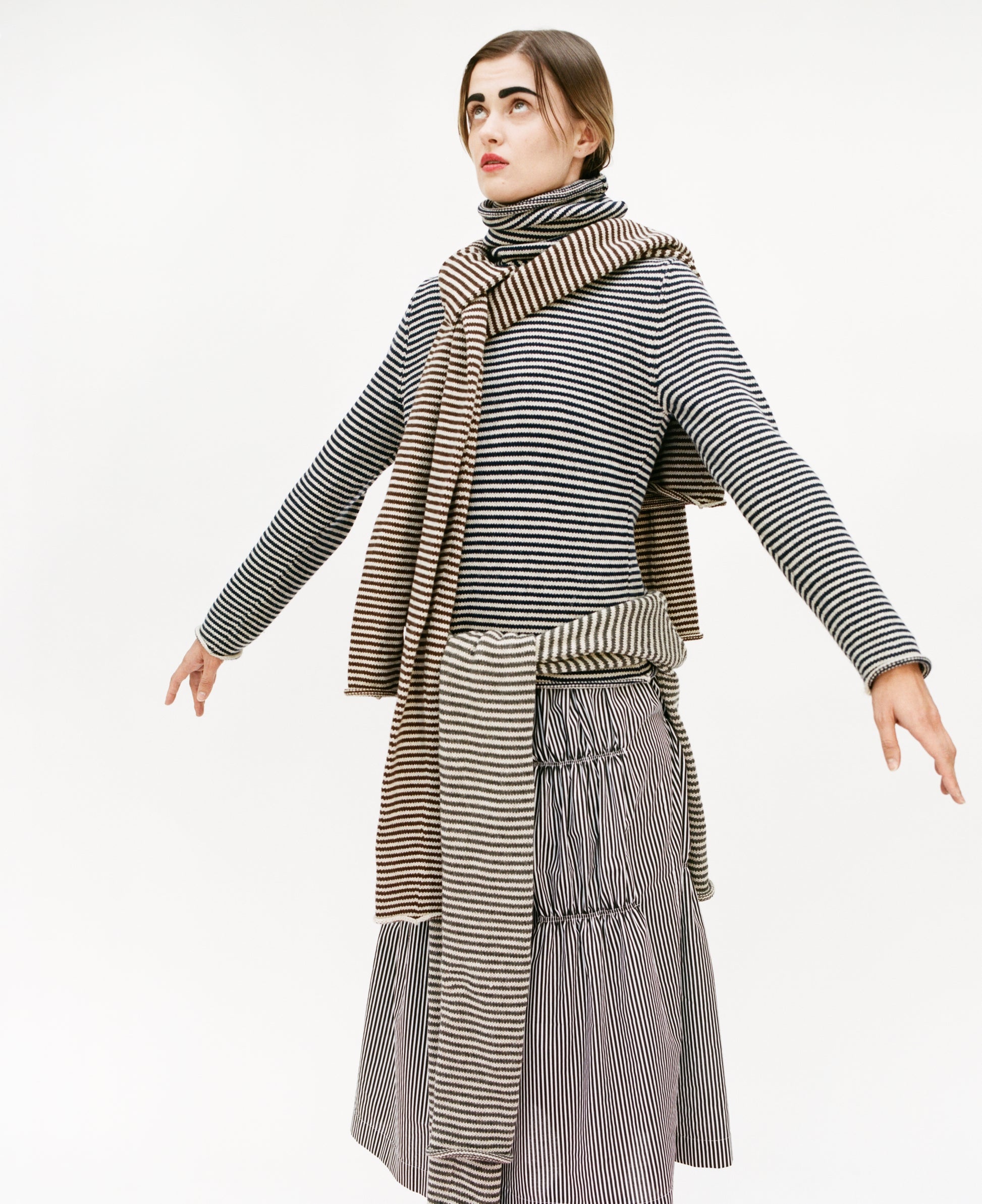 Model wearing full stripy outfit: Stripy snood sweater and ruche cotton skirt, with stripy snood sweater over the shoulders and stripy double snood sweater around the waist