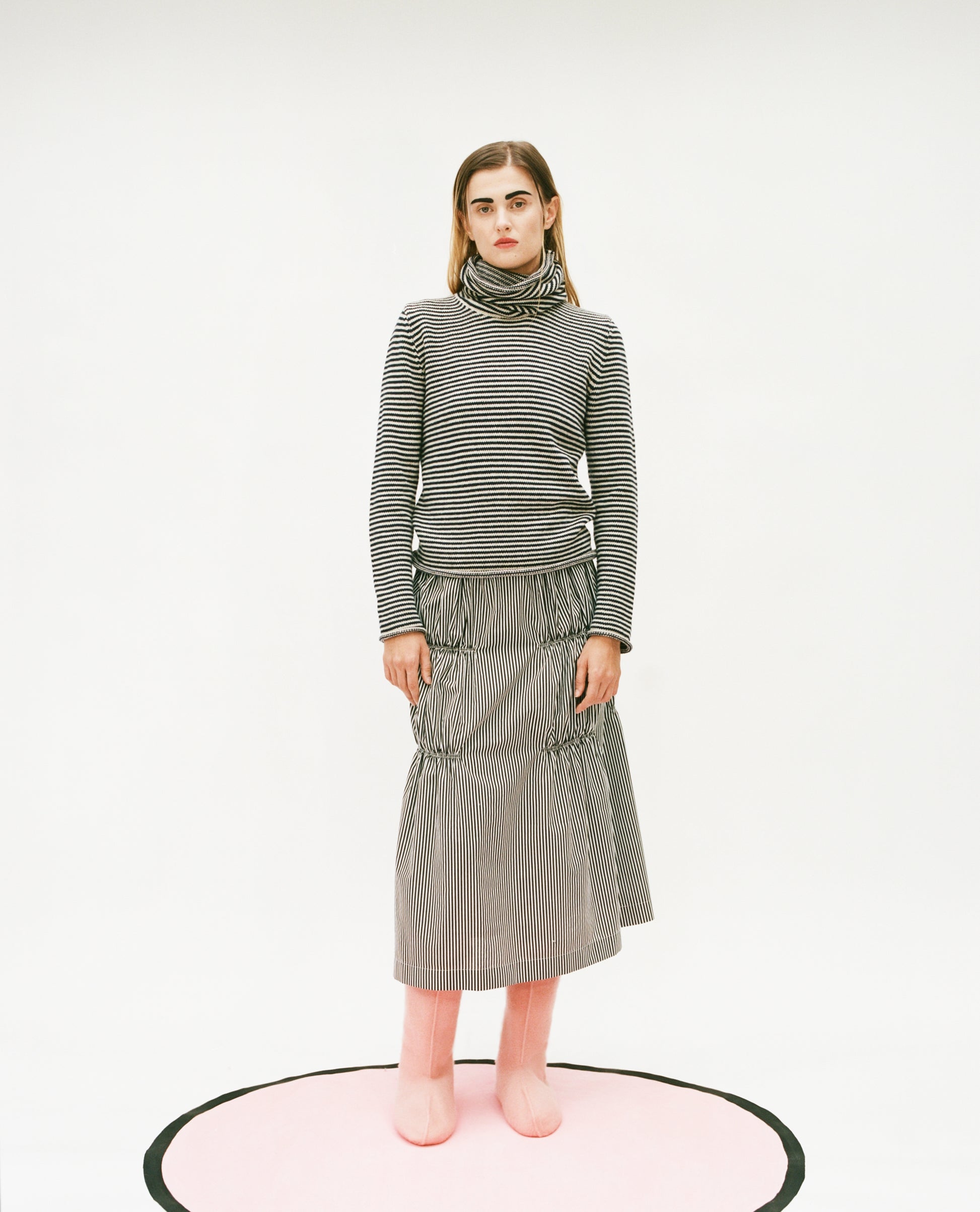 Model wearing the stripy snood top and Ruche cotton skirt in black & white with felt pink boots