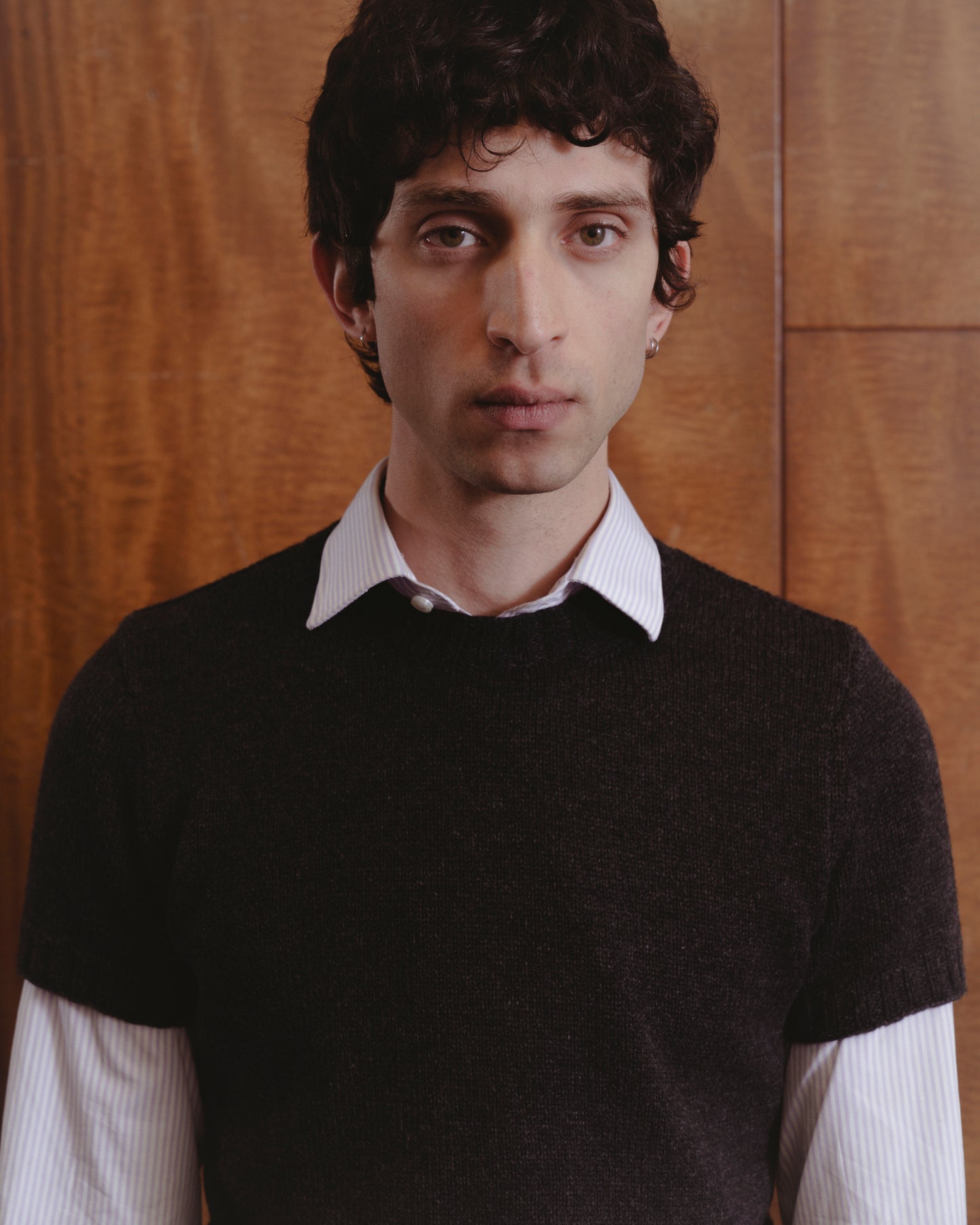 Male model wearing t-shirt sweater in charcoal over a long sleeve white shirt