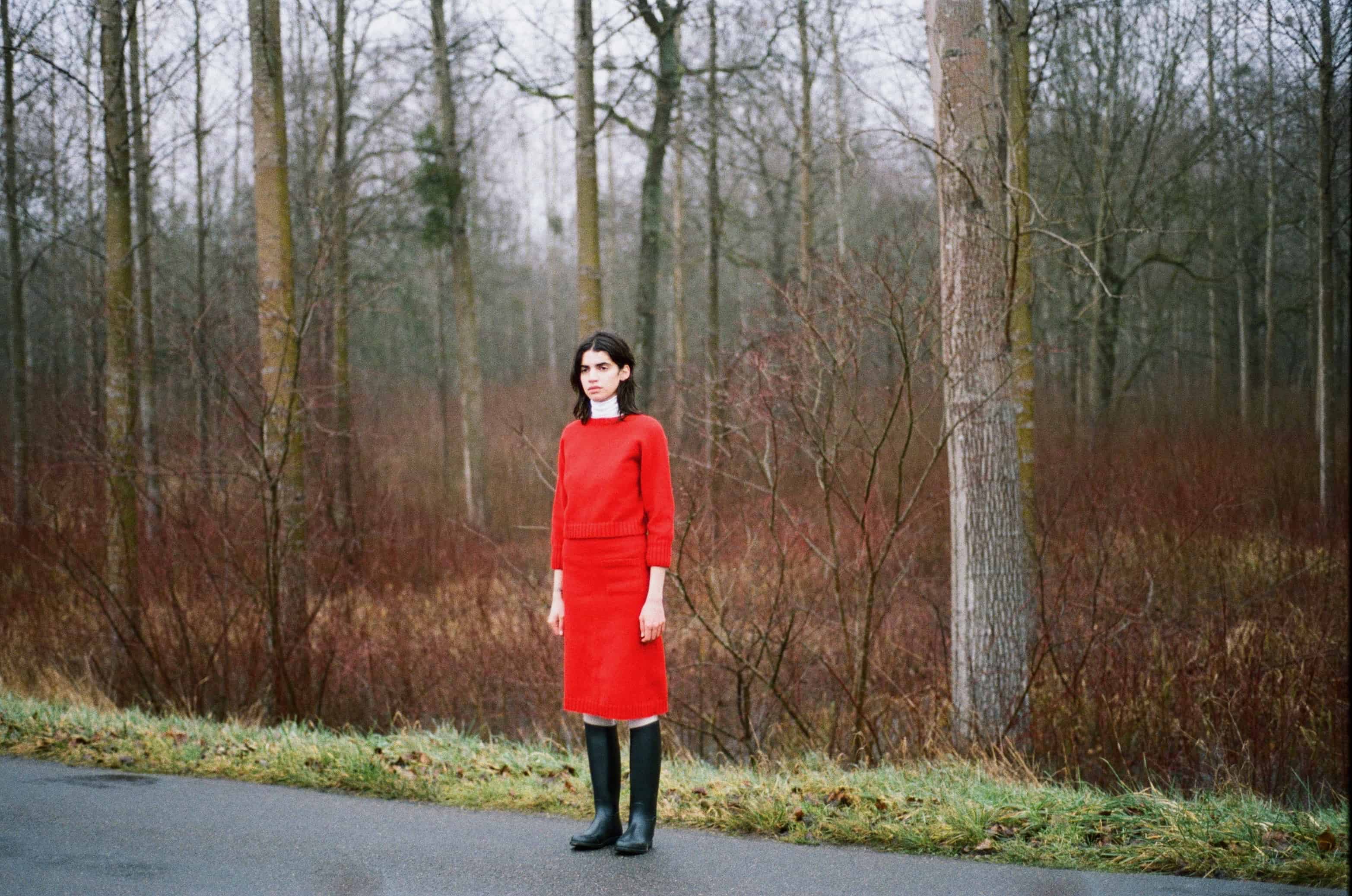 Model wearing matching red knitted jumper and knitted knee high skirt