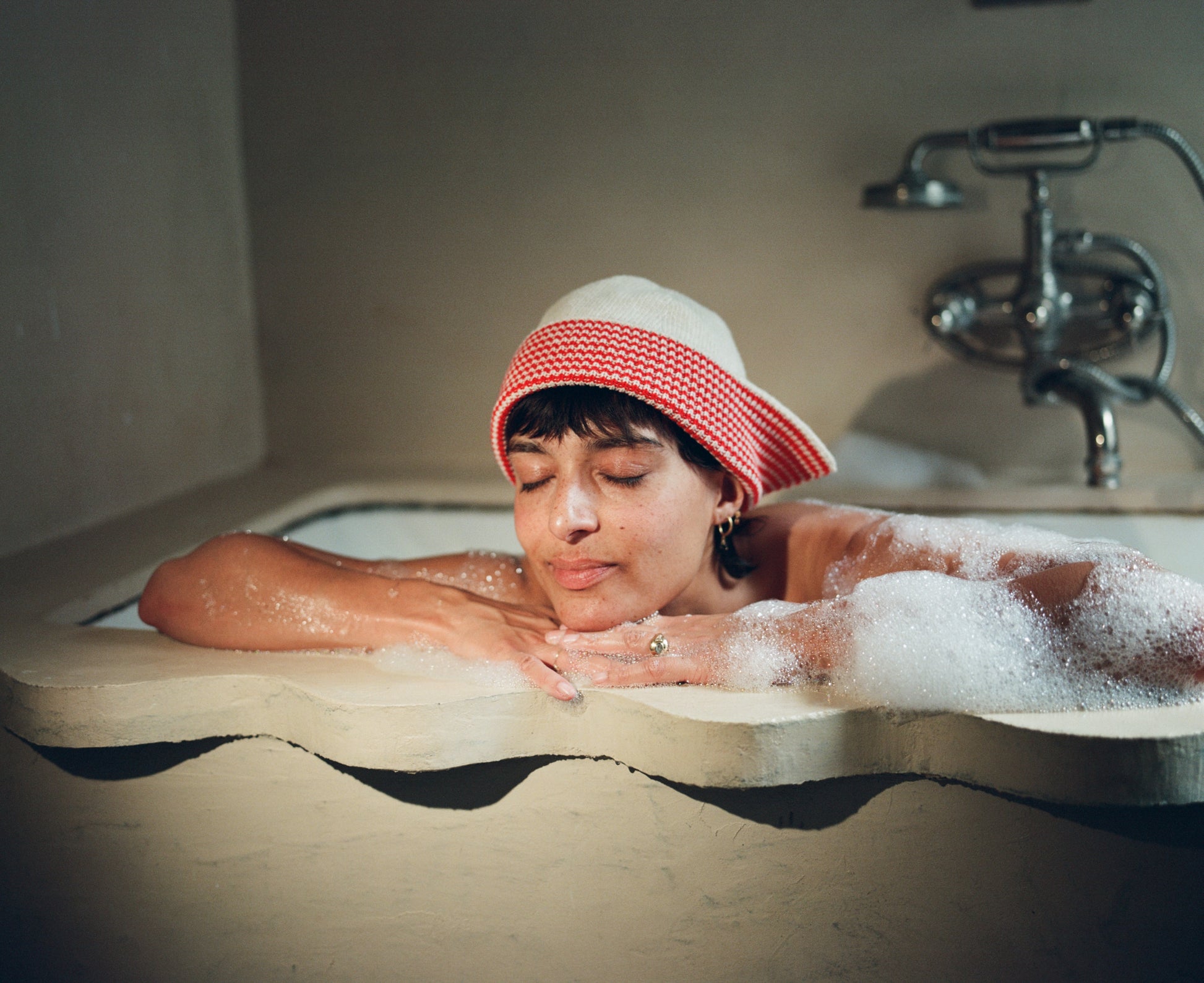 Model wearing the flap hat in oatmeal & red