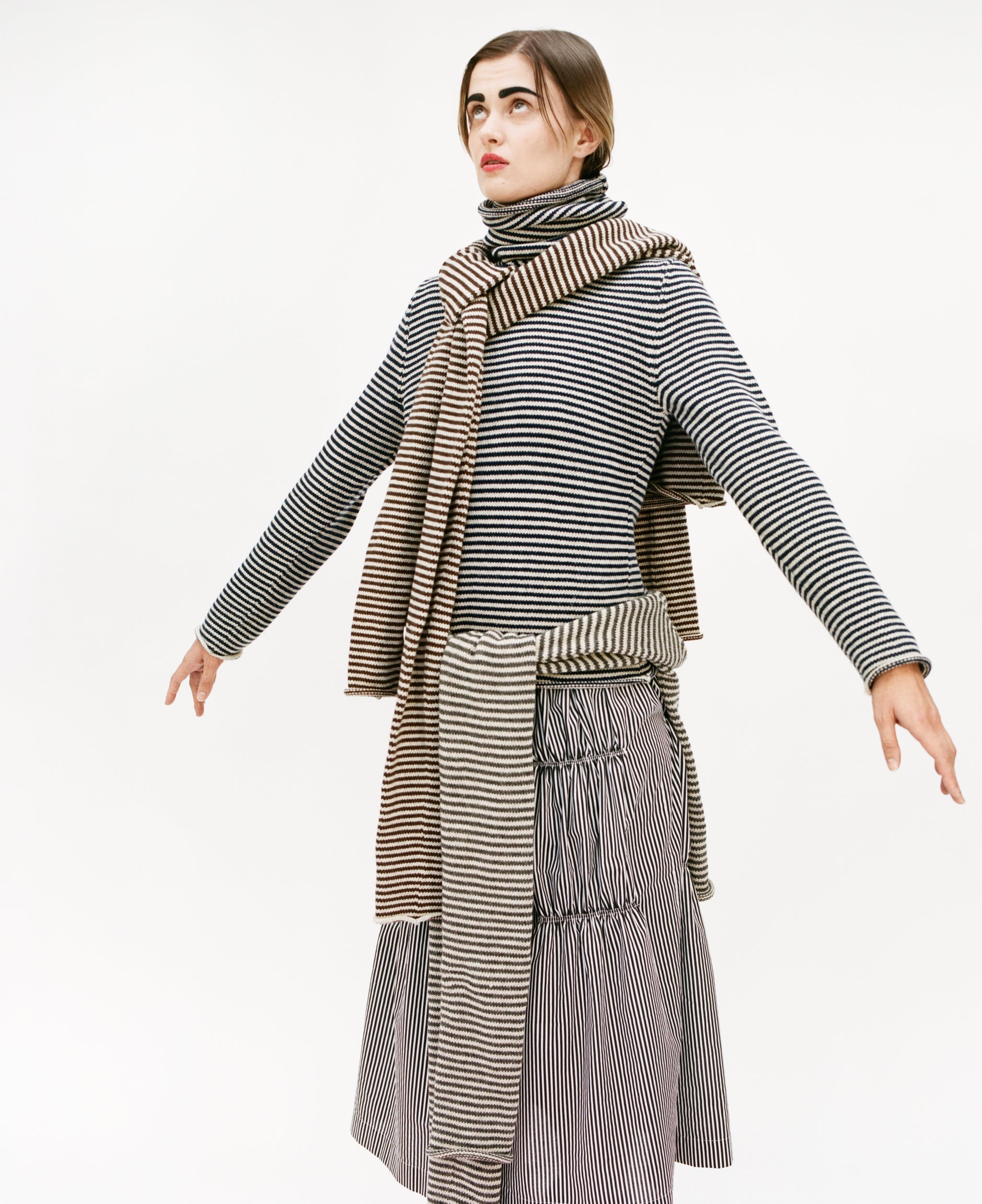 Model wearing full stripy outfit: Stripy snood sweater and ruche cotton skirt, with stripy snood sweater over the shoulders and stripy double snood sweater around the waist
