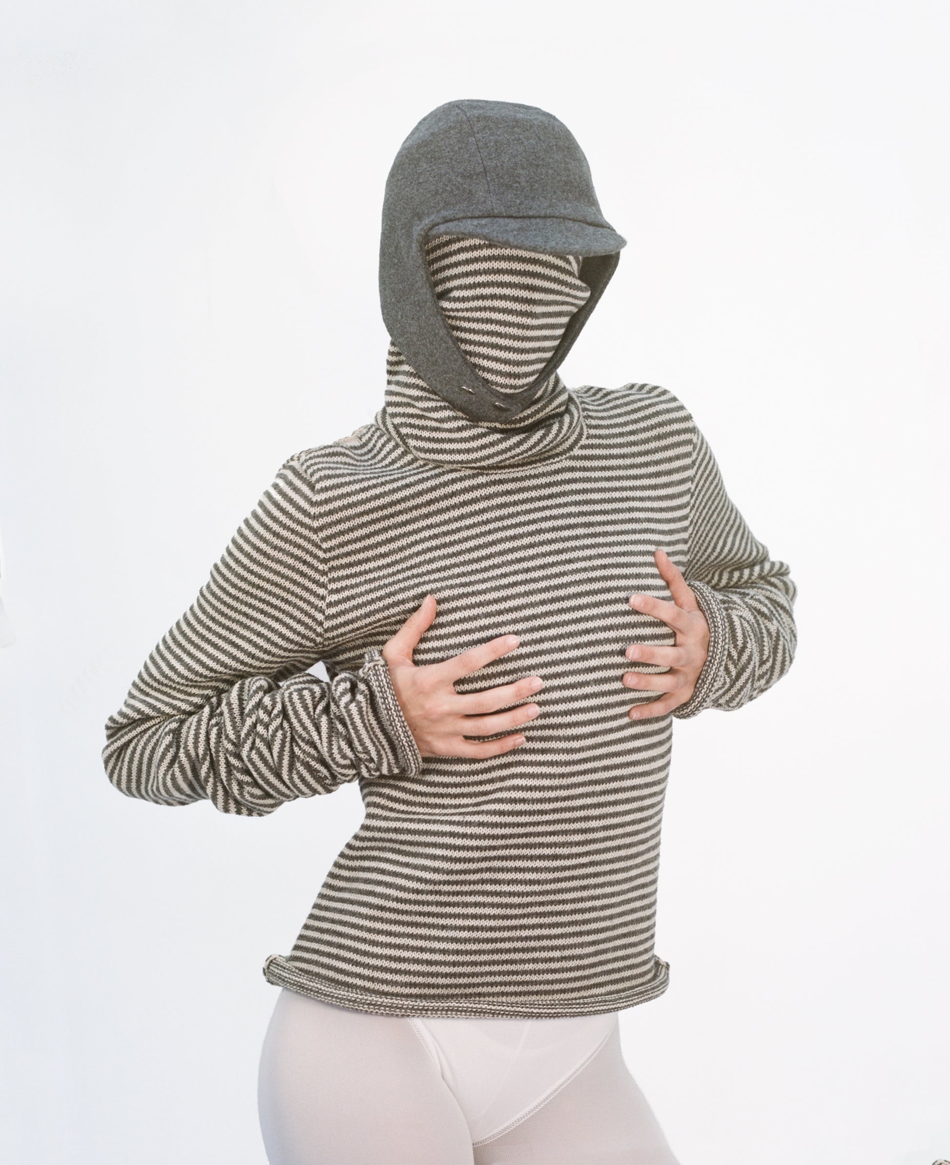 Model wearing flying hat over stripy double snood sweater