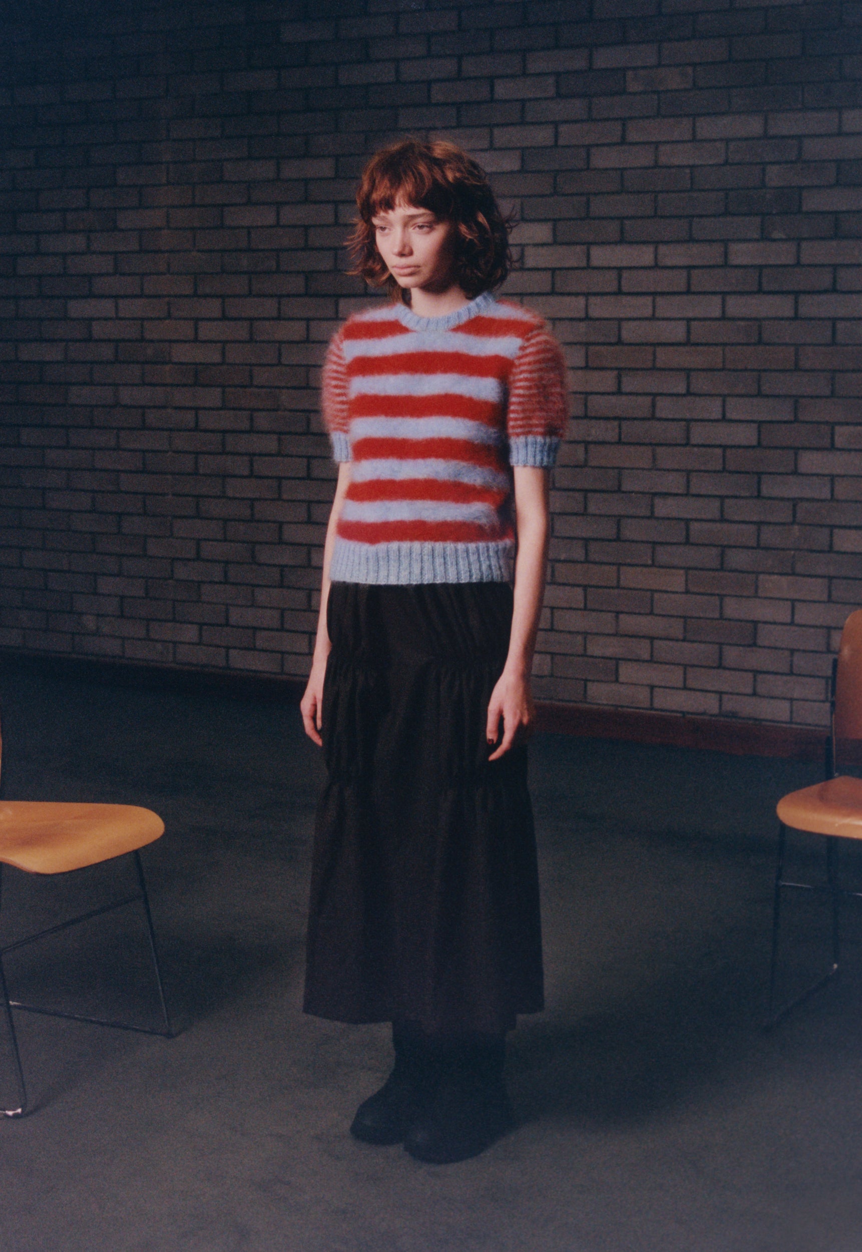 model wearing Mohair Stripe T-shirt Sweater in baby blue & dark orange with black ruche cotton skirt