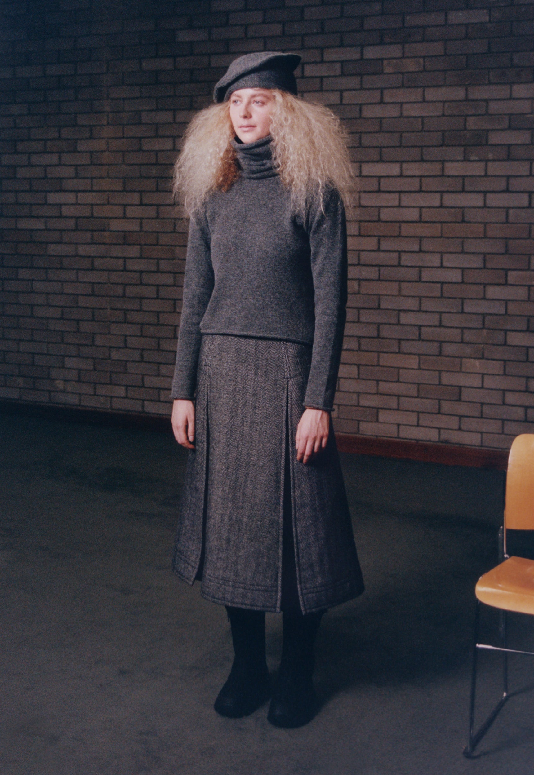 Look 5 - model wearing sack hat in mid-grey, snood sweater and Herringbone Double Zip Skirt