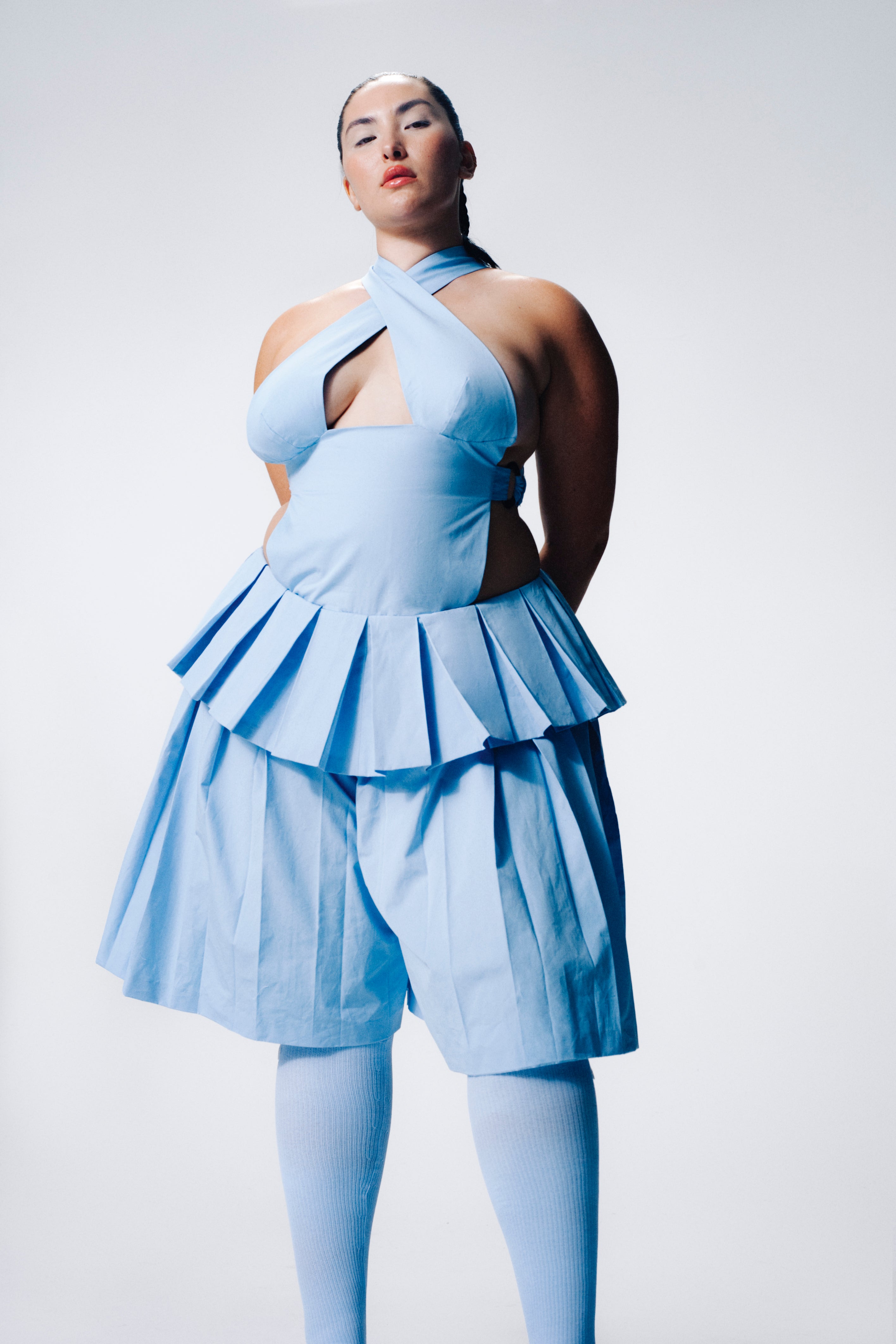 Model wearing baby blue top and pleated shorts with ribbed socks. Consulting for Sinead O'Dwyer, Squiggle