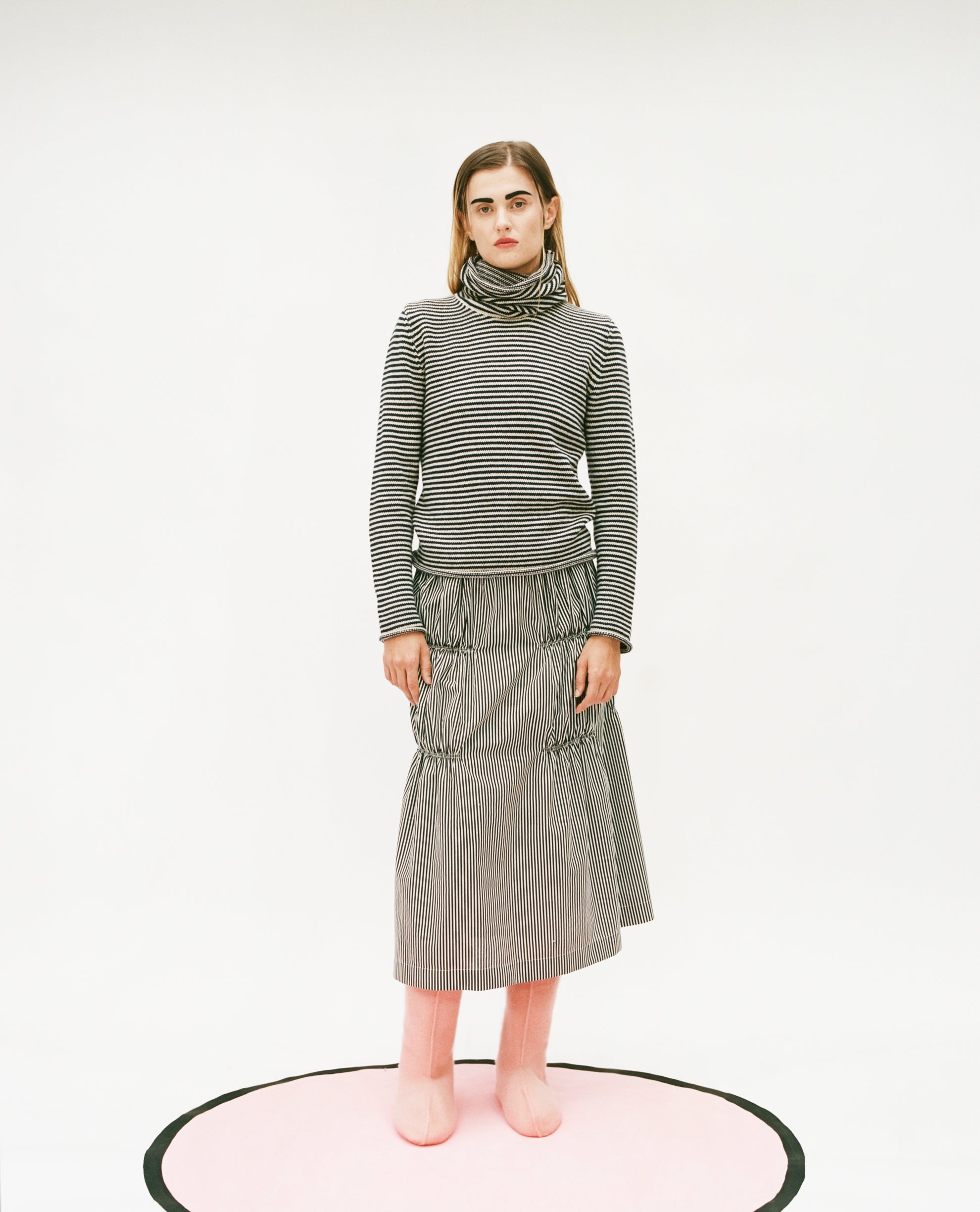 Model wearing the stripy snood top and Ruche cotton skirt in black & white with felt pink boots