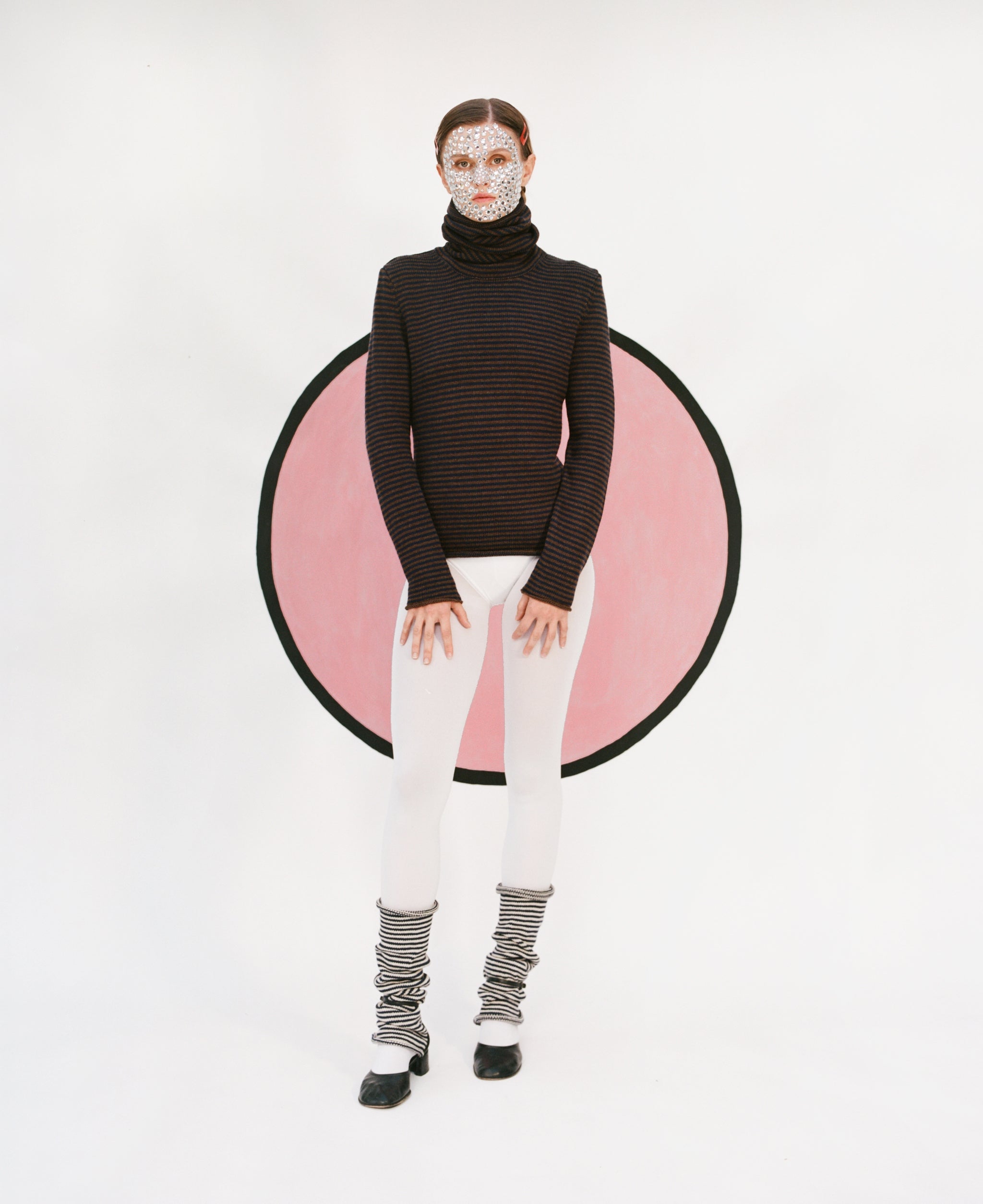 Model wearing stripy snood sweater in brown &  navy, white tights and stripy snood leg warmers in black & oatmeal