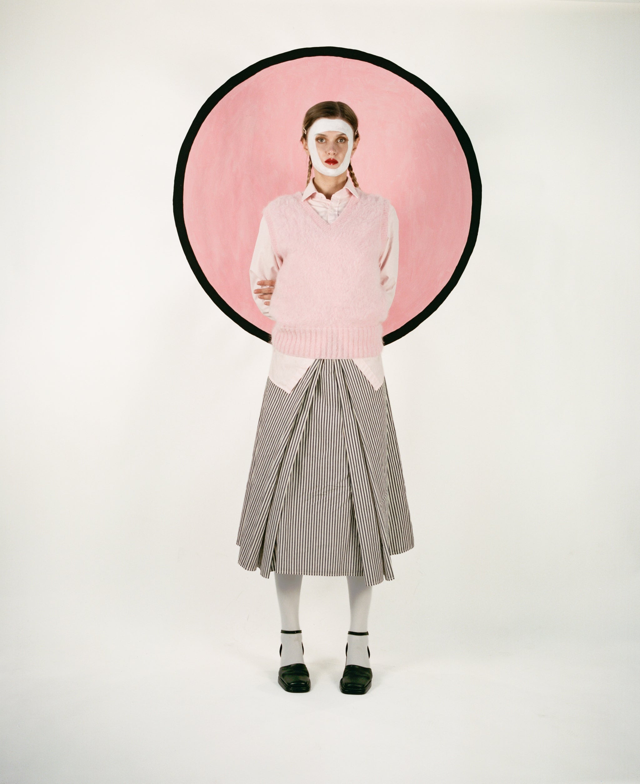 Model wearing pink shirt with matching vest and riche cotton skirt in black & white