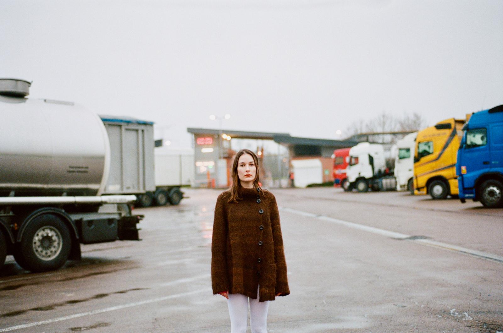 Model wearing 100% Handspun Alpaca cardigan with asymmetric opening and oversized black buttons