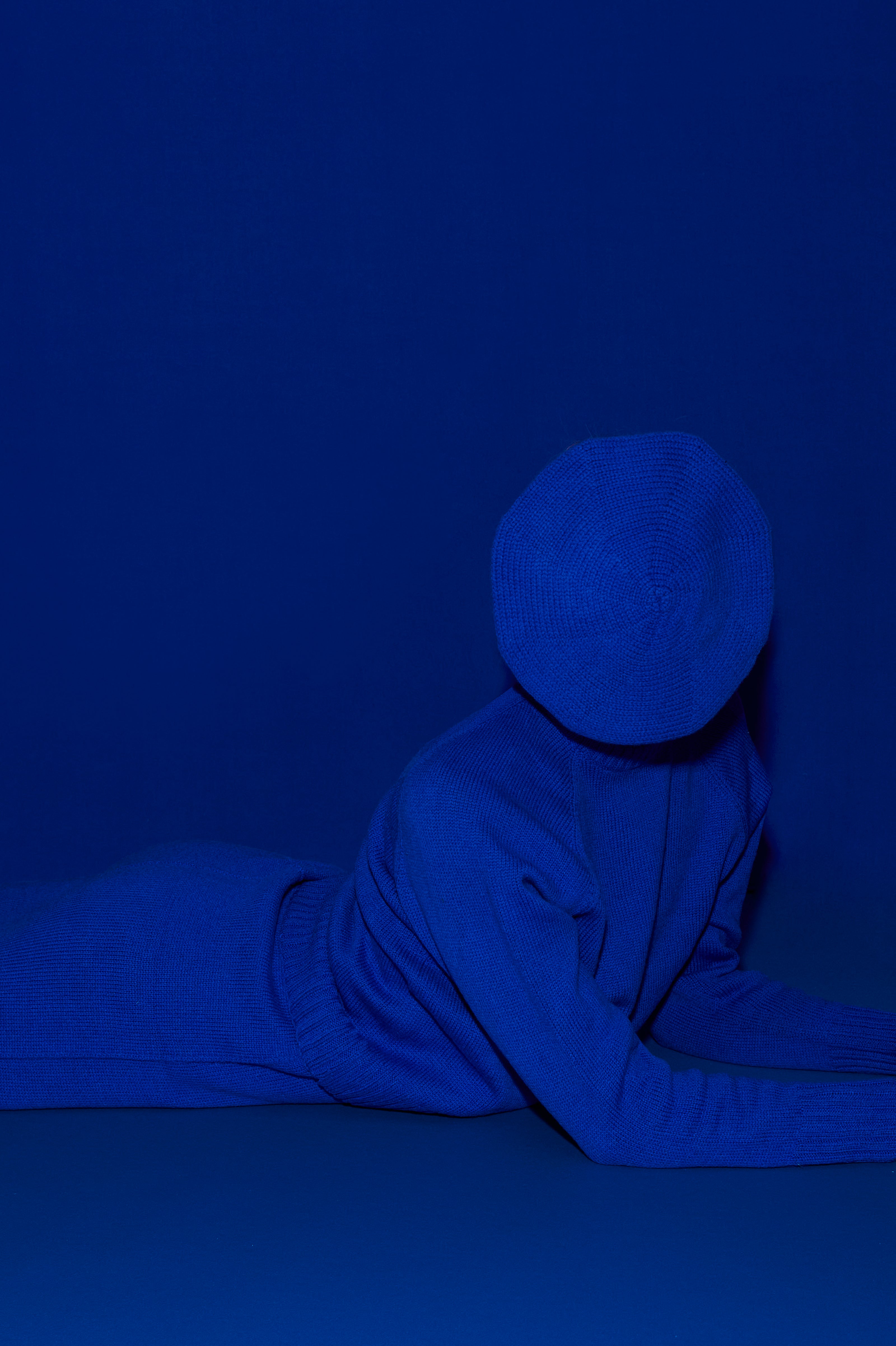 Full knit outfit: matching bright blue classic hat, top and skirt against a matching blue background