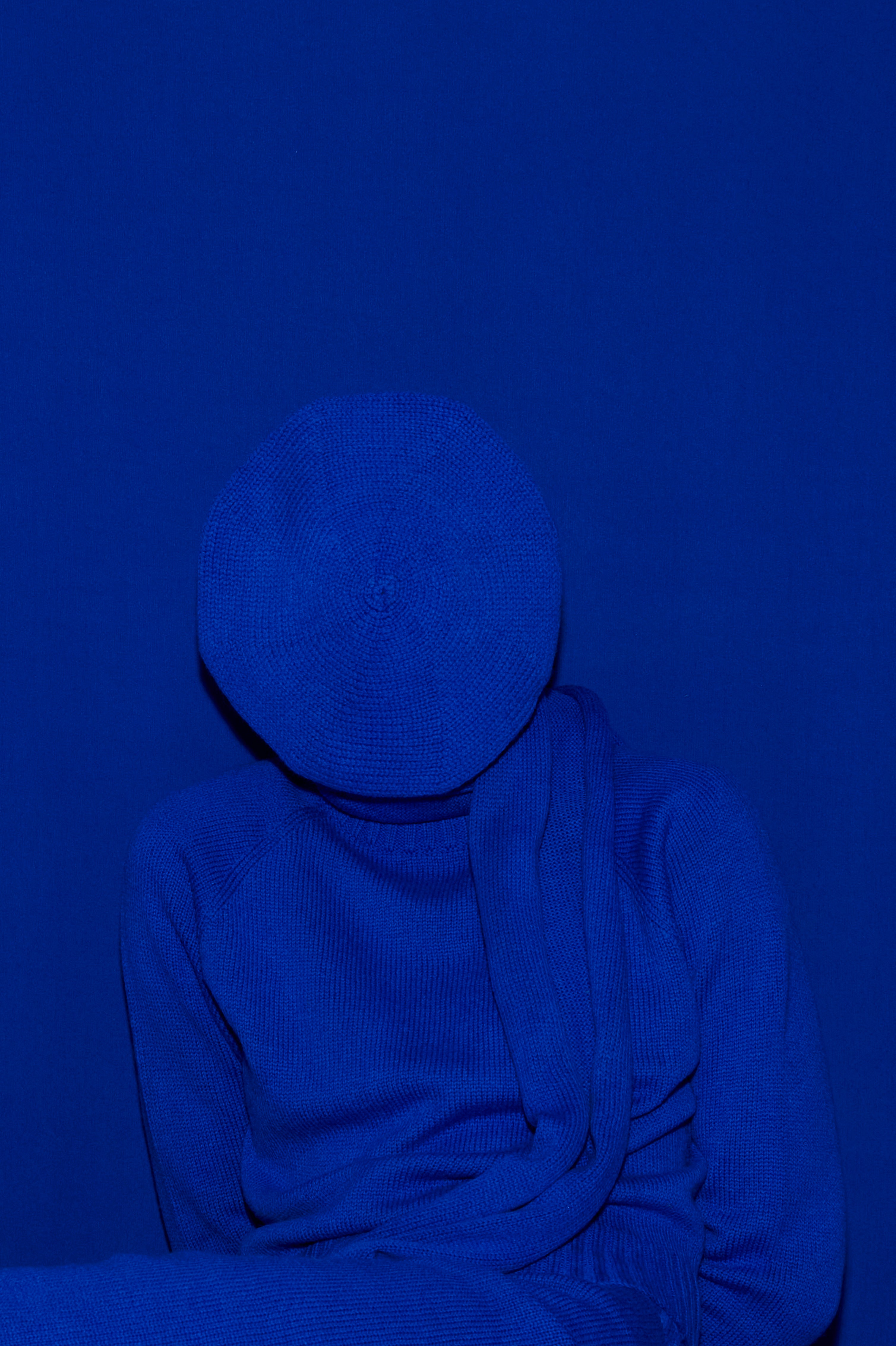 Full knit outfit: matching bright blue classic hat, top and skirt against a matching blue background