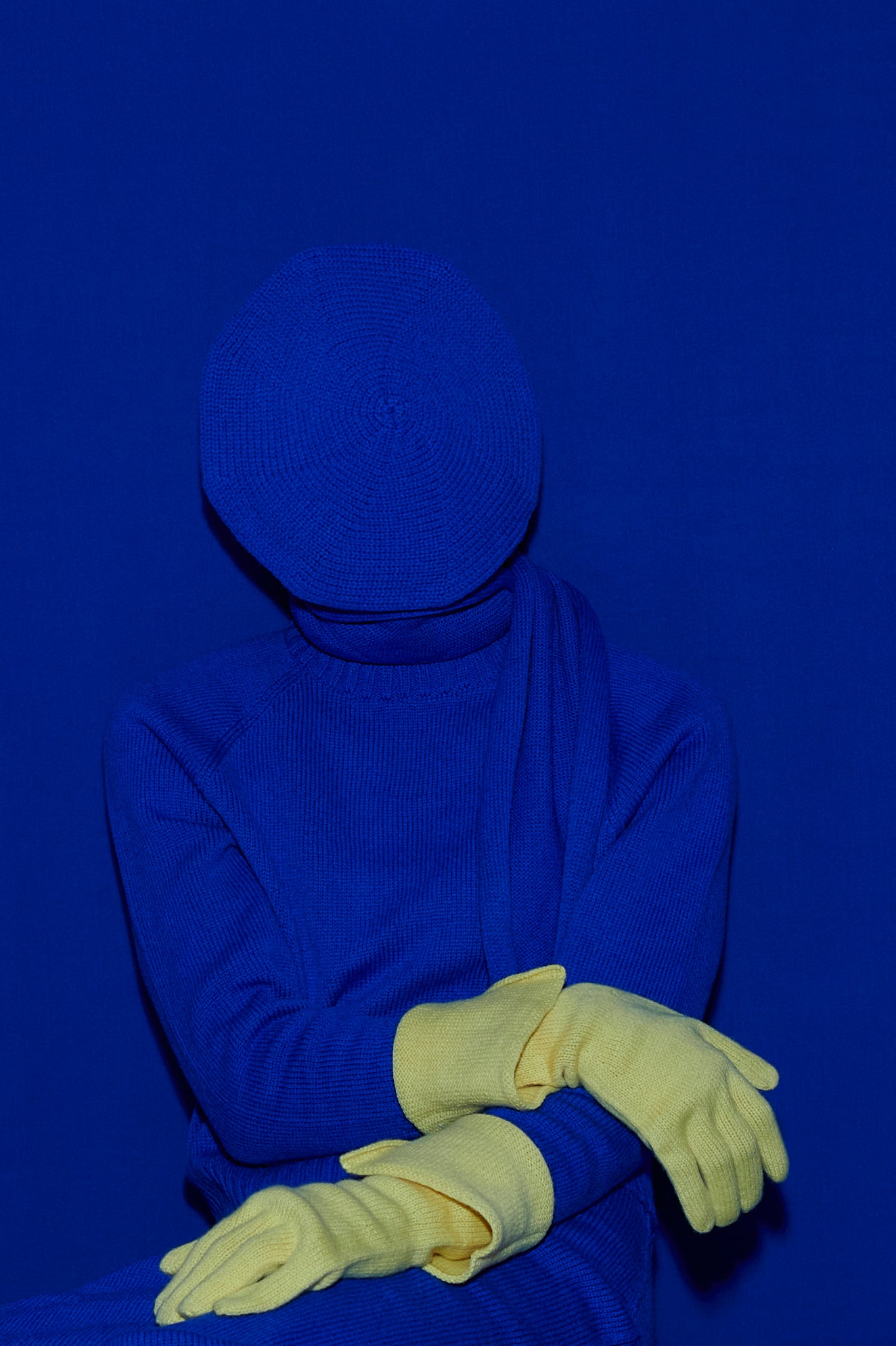 Full knit outfit: matching blue top and skirt and yellow gloves with a matching blue background