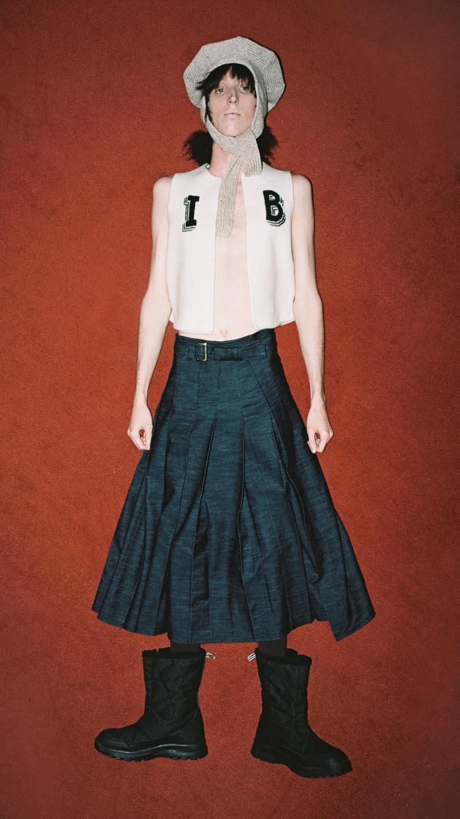 Look 12 - Model wearing classic hat in tweed, initials vest in ecru and black Ankle Pleat Skirt